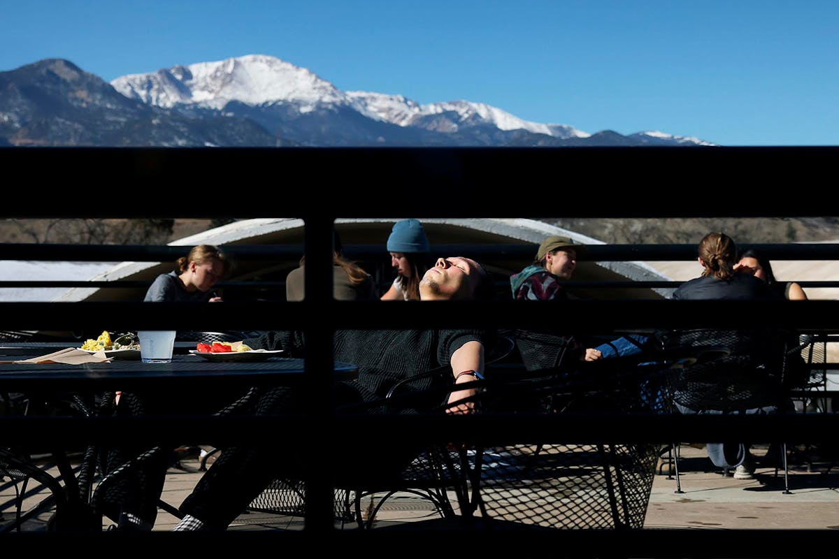 Students and others enjoy the sun and its warm rays on Rastall patio on Feb. 22 during Family Weekend. Photo by Jamie Cotten / Colorado College