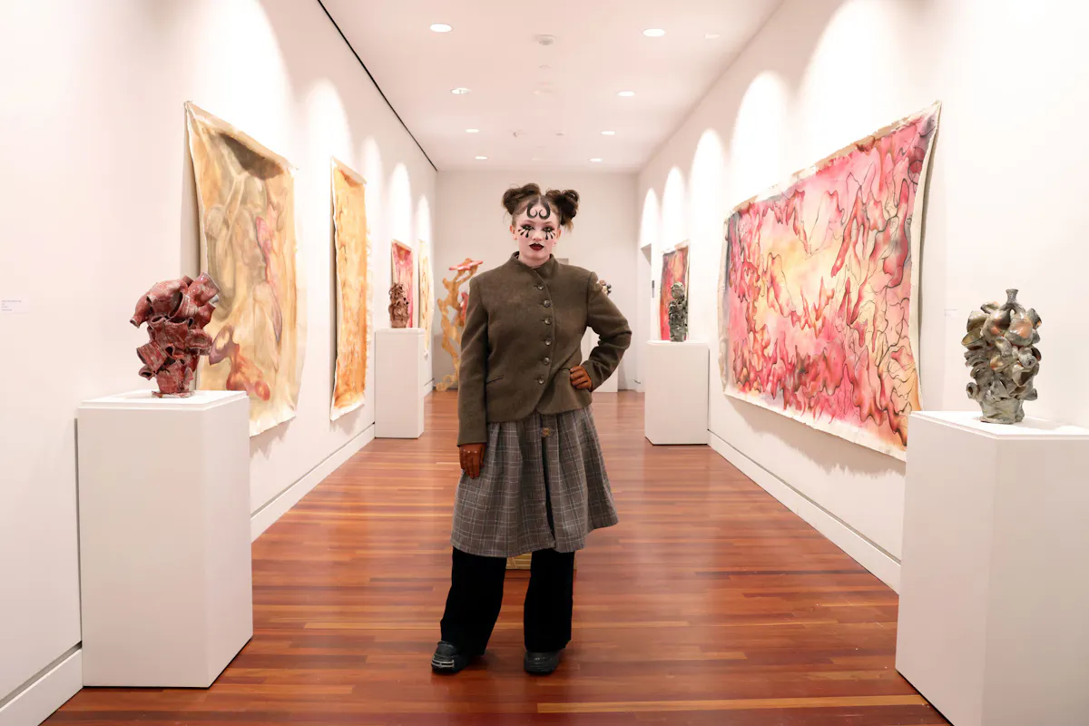 Senior Talia Cardin ’26 stands with her exhibit, "Der Tsirkus Dame: The Circus Lady" at First Friday on March 6 at the FAC.  Photo by Jamie Cotten / Colorado College