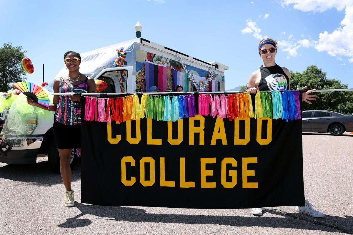 President Dr. Manya Whitaker (left) and Megan Clancy ’07 (right), Senior Writer and Editor, hold the Colorado College banner while preparing to march in the Pride Parade in downtown Colorado Springs on June 15. Photo by Jamie Cotten