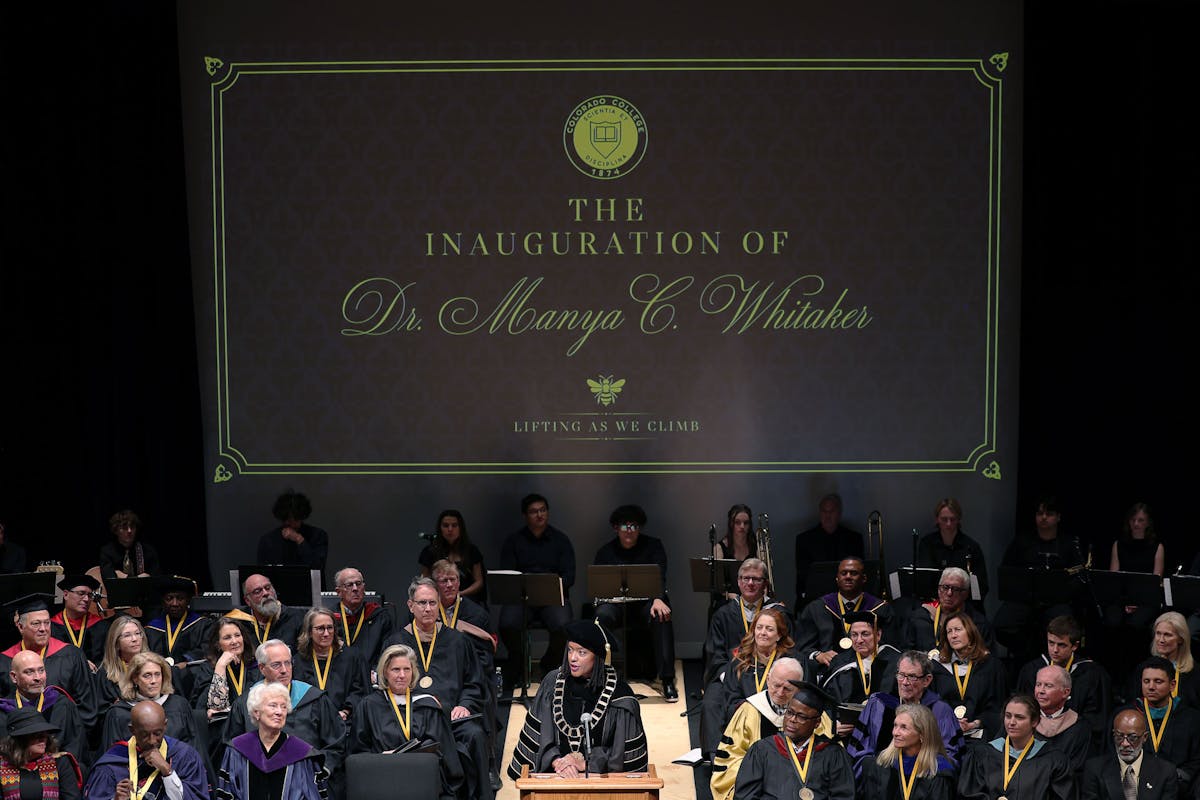Pres. Manya Whitaker speaks before a crowd of faculty, staff, students, visiting educators, her family and members of her sorority, as the Board of Trustees and other special guests sit behind her on stage on Nov. 8 at Celeste Theatre. Photo by Jamie Cotten / Colorado College