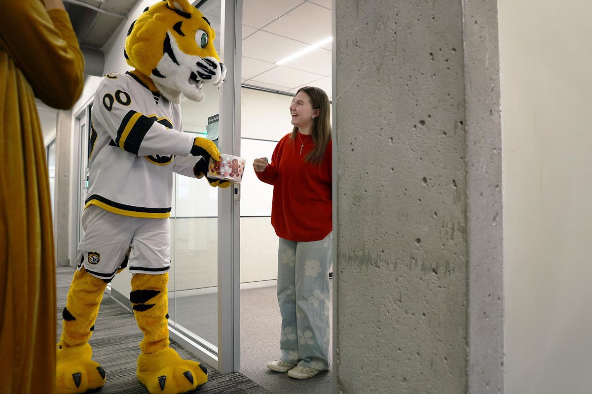 RoCCy walks around campus spreading holiday cheer on Dec. 11 by handing out treats, cards of kindness and appreciation, and by telling jokes written on large poster boards. Photo by Jamie Cotten / Colorado College