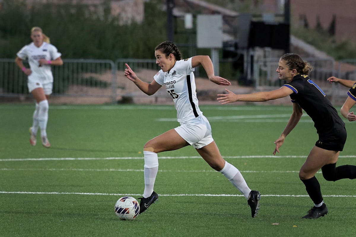 Brett Tsamasfyros '25 dribbles the ball during a game. Photo by Charlie Lengal for Colorado College