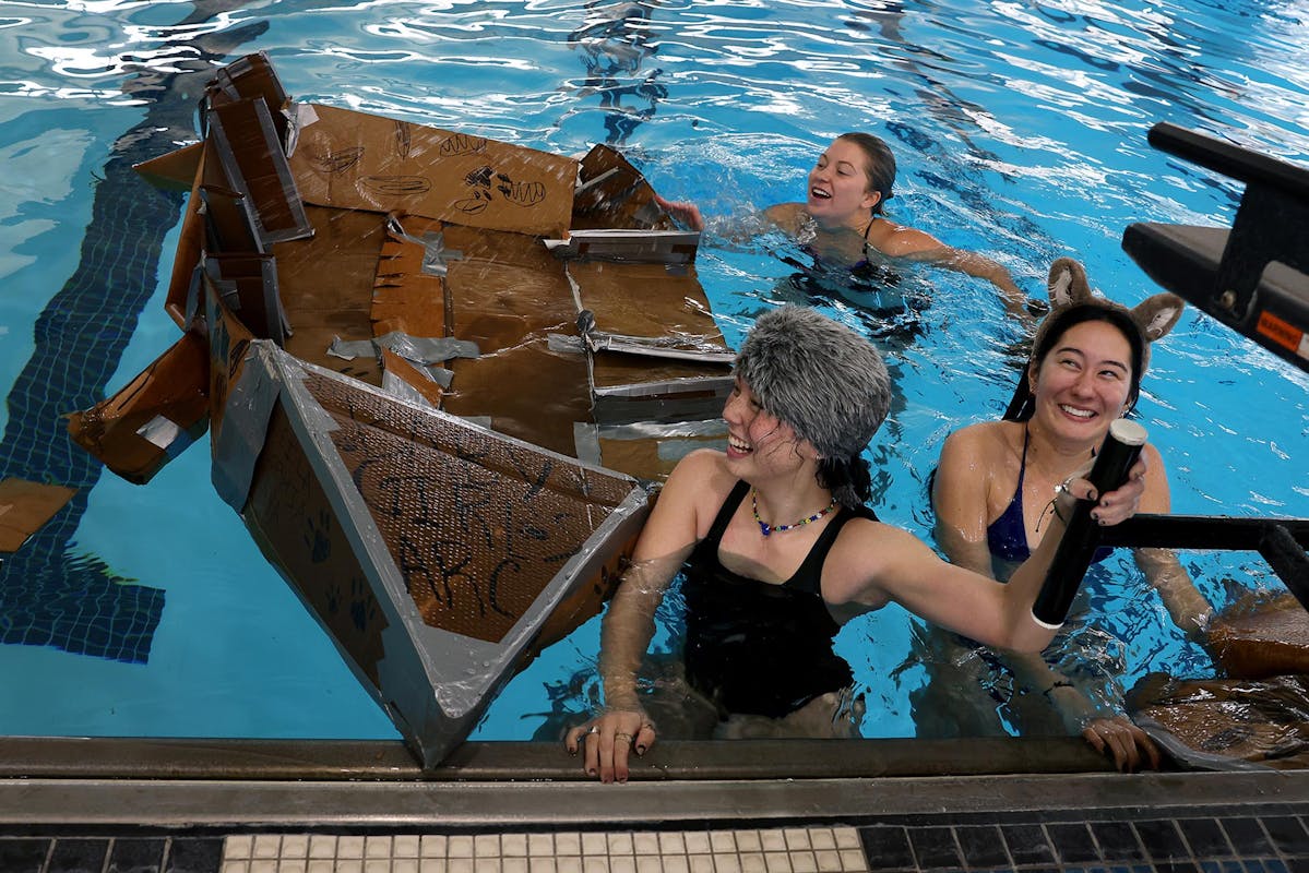  Students Anya Potsialdo '27, Sophia Murphy '27, and Leila Campbell '27 finish the SS Regatta race with their cardboard and duct-tape boat on Feb. 1 at Schlessman Natatorium. Over 50 students took part in the regatta which is part of Second Saturdays, a series of events the second Saturday of every block, that include pickleball tournaments, baseball and more. Photo by Jamie Cotten / Colorado College