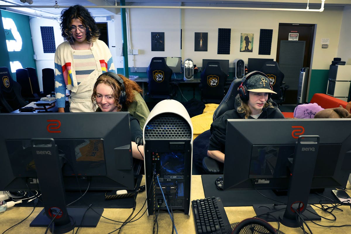 Kay Quintana, Logistics Co-Coordinator for CC E-Sports, left, watches others game during a "Firefly Fridays" evening, the first and third Fridays of every block, where participants order food and game into the night. Photo by Jamie Cotten / Colorado College
