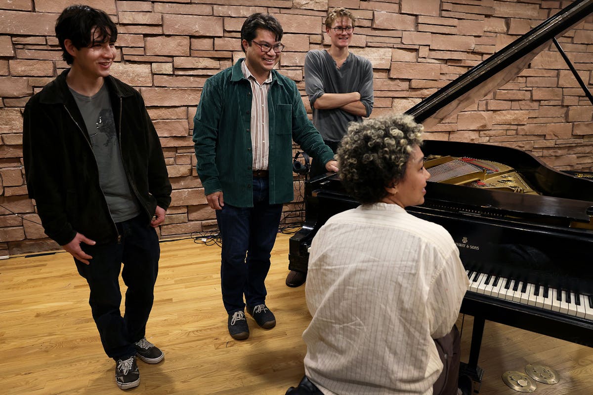Connor Chen ’25, left, Ryan Bañagale center, Eliot Kirkham ’25, right, and Iyanla Ayite ’25 at the piano. Photo by Jamie Cotten
