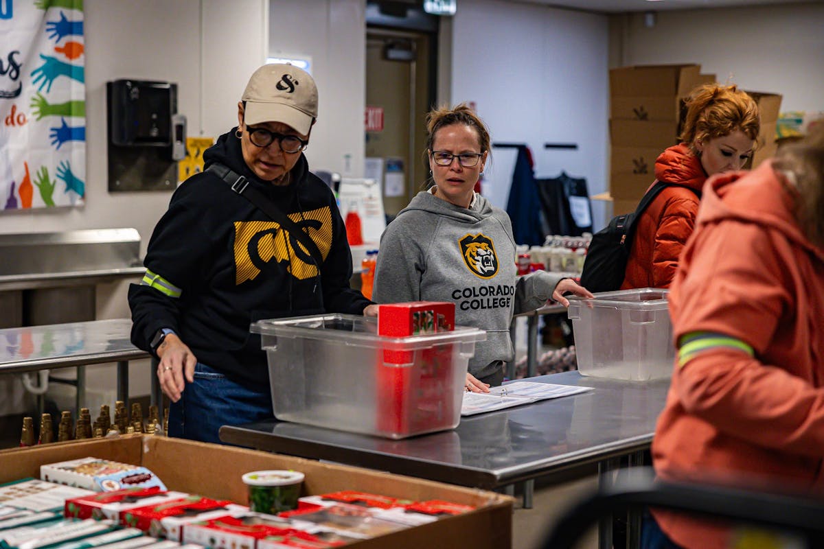 Naomi Trujillo P’20 , Serena Wolford P’27, and Jamie Cotten, all members of the Office of Communications & Marketing team, volunteering at Care and Share on Thursday, Jan. 15 during CC's Week of Action. Photo by Alexa Gromko